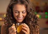 Happy young woman enjoying drinking ginger tea with lemon