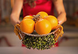 Closeup on christmas decorated plate with oranges in hand of wom