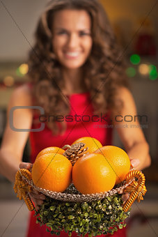 Closeup on christmas decorated plate with oranges in hand of you