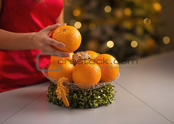 Closeup on young housewife decorating christmas plate with orang