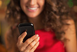 Closeup on cell phone in hand of woman in red dress