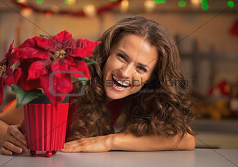 Smiling young woman looking out from christmas rose in christmas