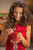 Happy young housewife lighting candle in christmas decorated kit
