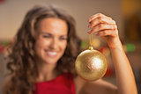 Closeup on christmas ball in hand of woman in red dress
