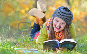 beautiful girl with book in autumn park