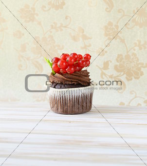 Chocolate cupcake with red currant in the romantic scenery