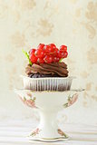 Chocolate cupcake with red currant in the romantic scenery