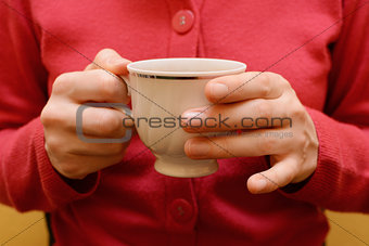 Woman holding a teacup in two hands
