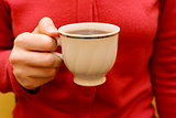 Woman with a cup of black tea in her hand