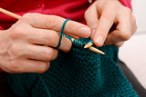 Closeup of woman knitting with teal wool