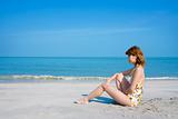 swimsuit woman sitting by the beach
