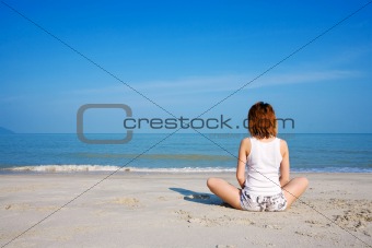woman meditating facing to the sea