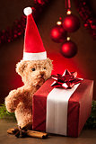 Teddy bear with red santa claus hat and christmas presents