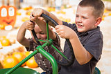 Adorable Young Boys Playing on an Old Tractor Outside