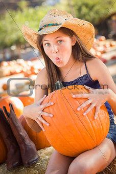 Preteen Girl Holding A Large Pumpkin at the Pumpkin Patch 