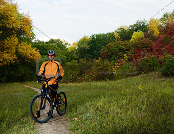 Cyclist with Bike in the Beautiful Autumn Forest