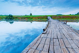 wooden bridge over a small lake in the early morning