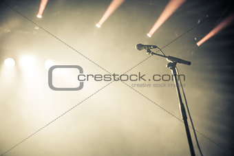 Microphone on empty stage waiting for a voice
