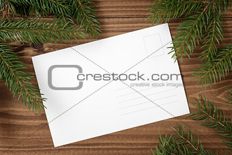 green spruce twig on wooden plank witc greeting card