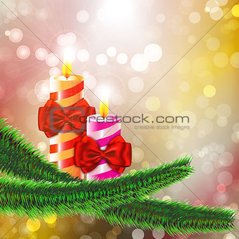 Two burning candles with bows on Christmas tree branch