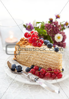 Piece of homemade honey cake decorated with fresh berries