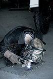 mechanic welding the exhaust of a motorbike