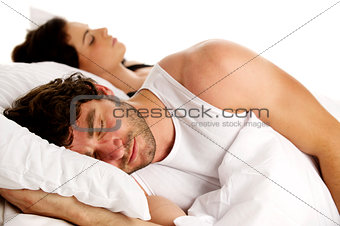 Man laid in white bed next to a woman sleeping