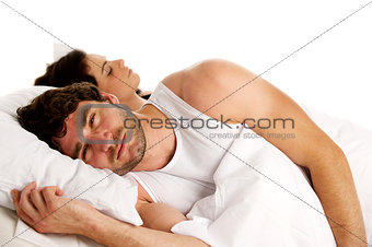 Man laid in white bed next to a sleeping woman