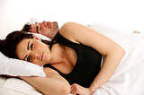 Woman laid in white bed next to a sleeping man