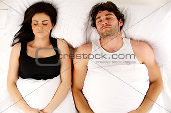 Man and woman laid in bed sleeping