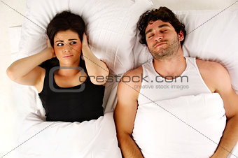 Man snoring keeping woman awake in bed
