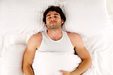 Man laid in white bed sleeping