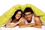 Beautiful couple in bed under a green duvet