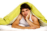 Man tired in bed under a green duvet