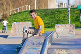 smiling teenage boy in roller-blading protection kit in a skate 