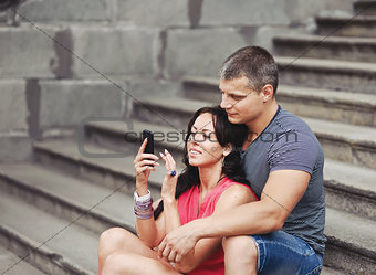 Young couple of tourists sitting on steps