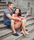 Young couple of tourists sitting on steps