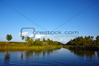 Summer landscape with a river and trees on the coast
