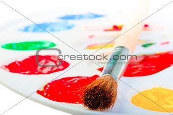 Artist's brush on a white palette with paints