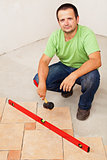 Worker laying ceramic floor tiles
