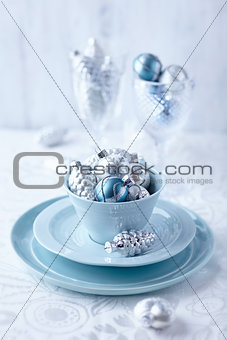 Silver and blue christmas ornaments in a cup