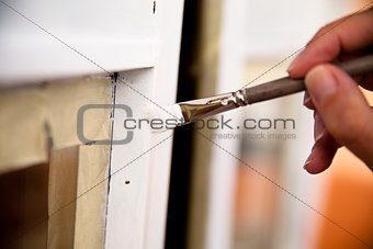 hands of a girl painting a window
