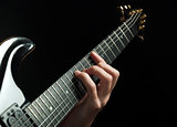 guitarist hand playing guitar over black