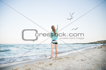 Young Girl at Beach are Feeding Seagulls