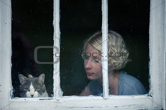 Woman and Cat Looking at the Rainy Weather By the Window