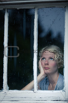 Bored Woman Looking at the Rainy Weather By the Window