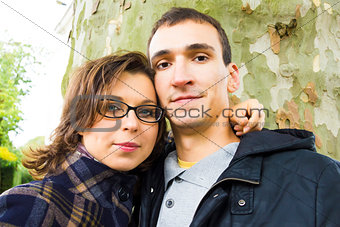 Portrait of love couple embracing outdoor looking happy