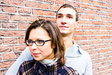 Portrait of love couple embracing looking happy against wall bac