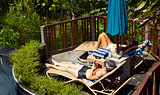 women sunbathing beside pool