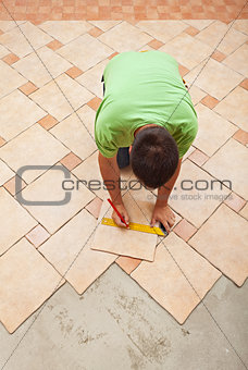 Man laying ceramic floor tiles